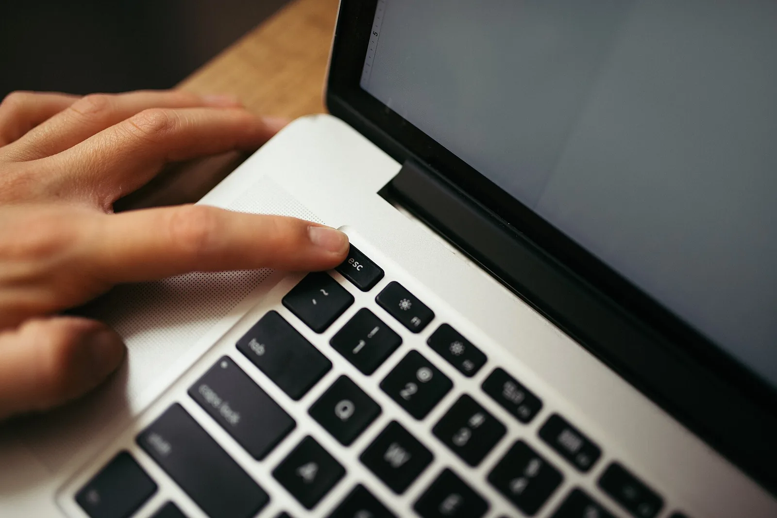 A hand typing on a laptop keyboard, as students check AI tools before trusting them