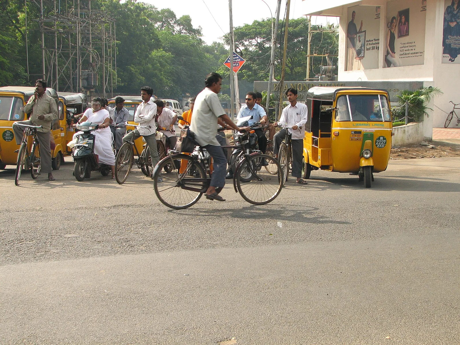 Tamil Nadu-registered auto rickshaws and cyclists at a road junction, file photo