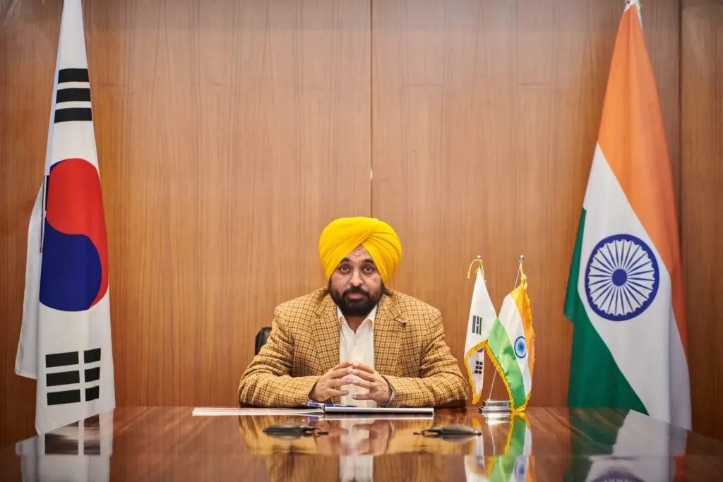 Bhagwant Mann seated at a table between Indian and Korean flags, AAP Punjab candidates file photo