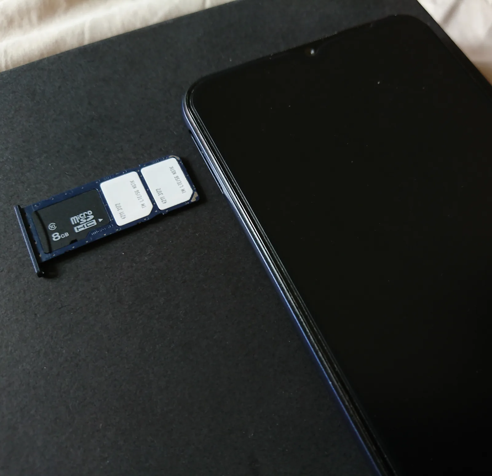 Dual SIM tray taken out of a smartphone; SIM binding needs the registered SIM inside