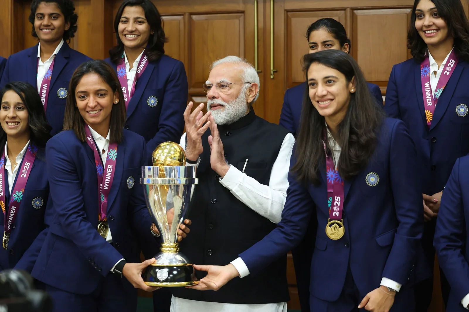 Harmanpreet Kaur and Smriti Mandhana with the 2025 World Cup trophy and India's team, file photo
