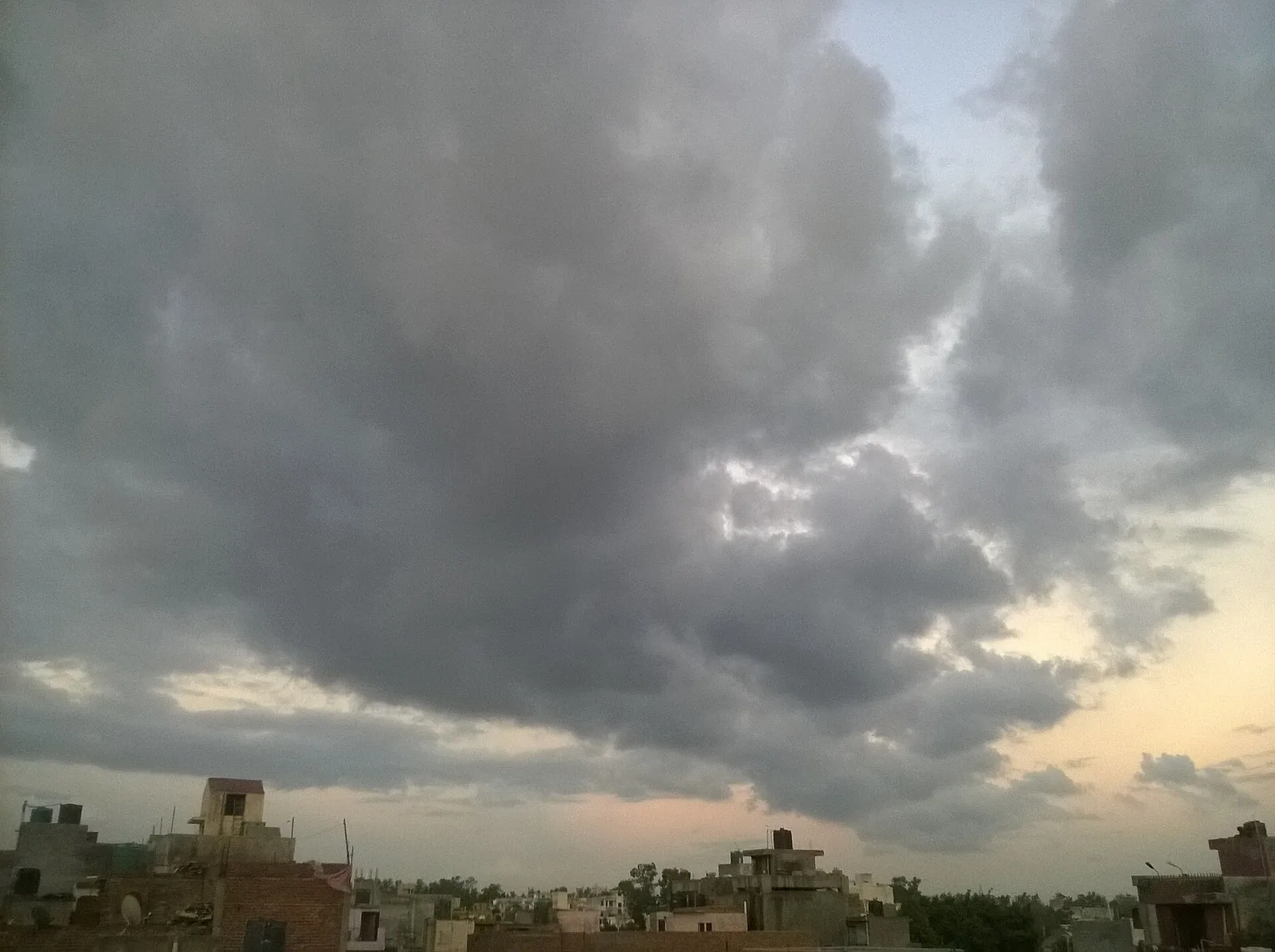 Houses under monsoon clouds near Najafgarh, close to several Delhi villages