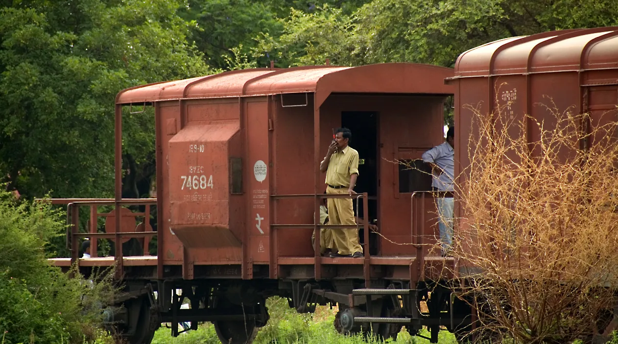 Indian Railways goods train guard using a walkie-talkie from the brake van, file photo