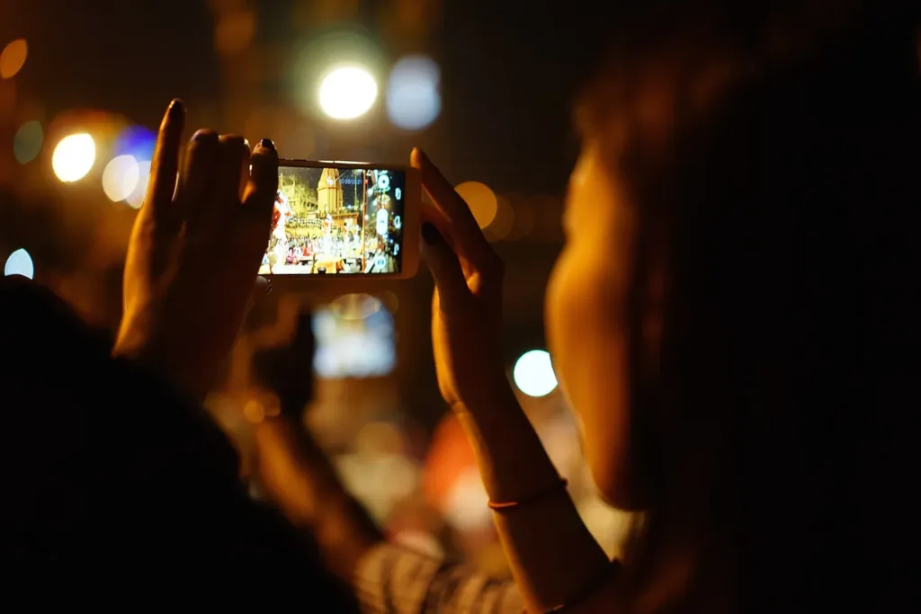 Person filming on a smartphone at night, representative image for the AU Bank data leak probe