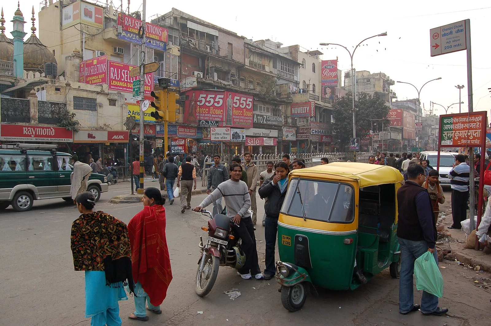 Shoppers and auto rickshaws on Chandni Chowk Road in Old Delhi
