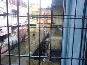 Waterlogged residential lane in Chennai seen through a window during Tamil Nadu rain