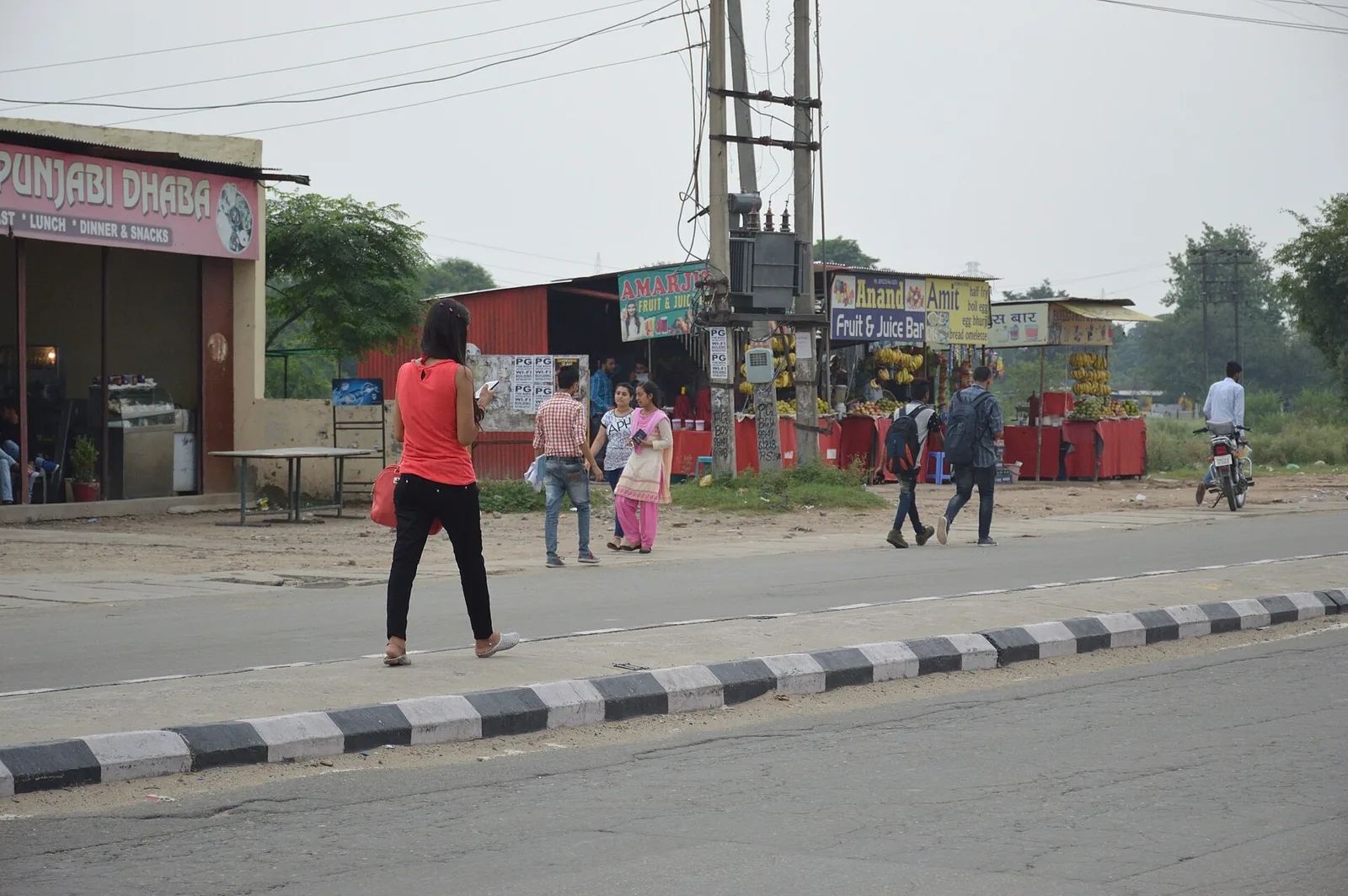 Woman using a smartphone on a roadside in Mohali, Punjab, file photo